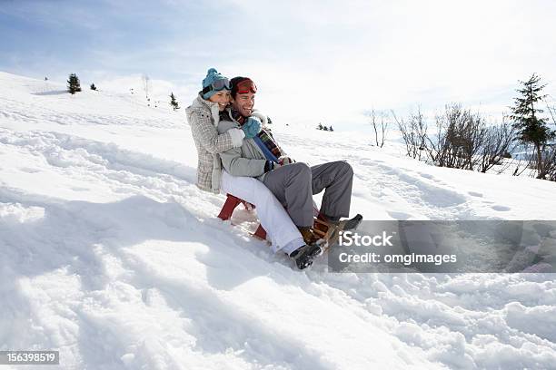 Pareja Joven Paseos En Trineo Foto de stock y más banco de imágenes de Deslizarse en trineo - Deslizarse en trineo, Hacer tobogán en la nieve, Parejas