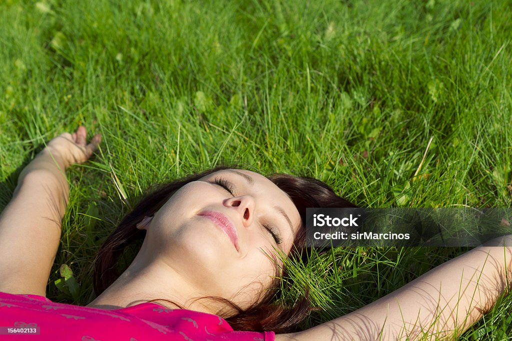 leisure time young woman relaxing on the grass in the park in summer Adult Stock Photo