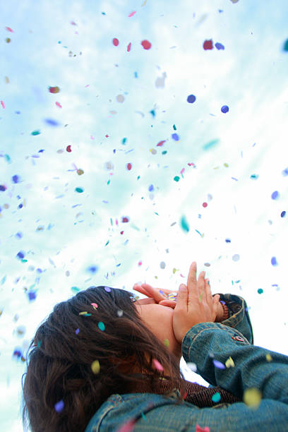 istock Girl throwing confetti into the sky. 156405319