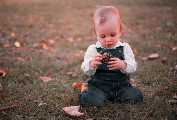 istock Baby boy kneels on the grass 1564065691