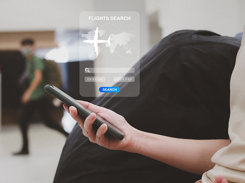 Air tickets online, young women searching for travel dates through applications on smartphones in air ticket booking