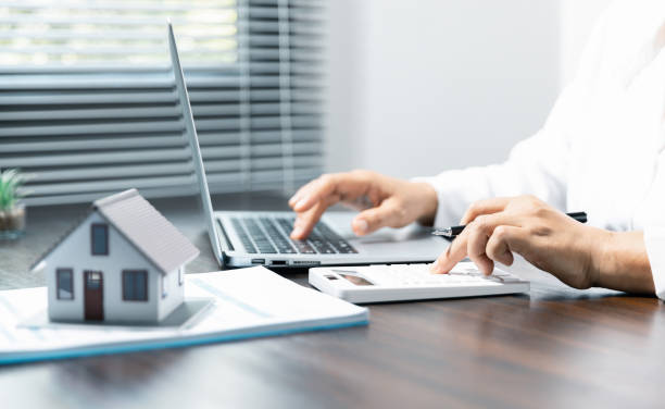 istock Close up female hands using calculator and writing with calculations on home office expenses. 1564146103