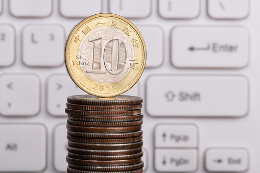 10 chinese yuan coin on computer keyboard background