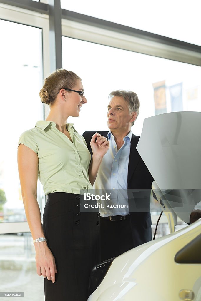 Hombre y mujer en salón de coches vista por debajo de una campana de extracción - Foto de stock de Adulto libre de derechos