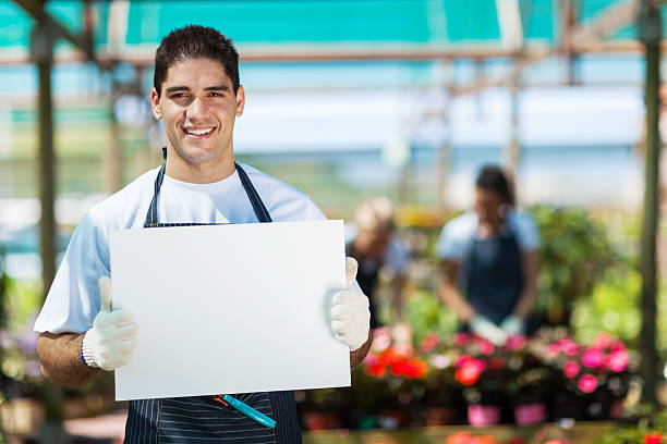 happy gärtner holding whiteboard - greenhouse gardening formal garden whiteboard stock-fotos und bilder