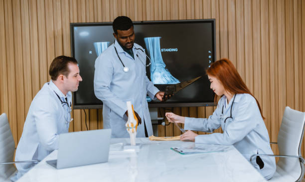 istock Surgeon and radiologist discuss Pt's ankle's MRI for treatment plan. Multicultural boardroom meeting 1564223055