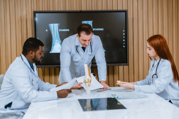 istock Surgeon and radiologist discuss Pt's ankle's MRI for treatment plan. Multicultural boardroom meeting 1564230457