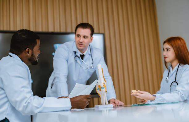 istock Surgeon and radiologist discuss Pt's ankle's MRI for treatment plan. Multicultural boardroom meeting 1564237337