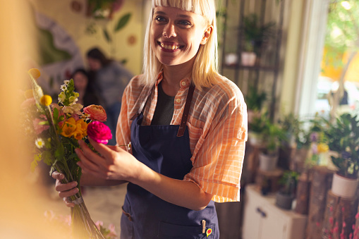 The owner of a flower shop works in a flower shop, makes flower arrangements, small business concept