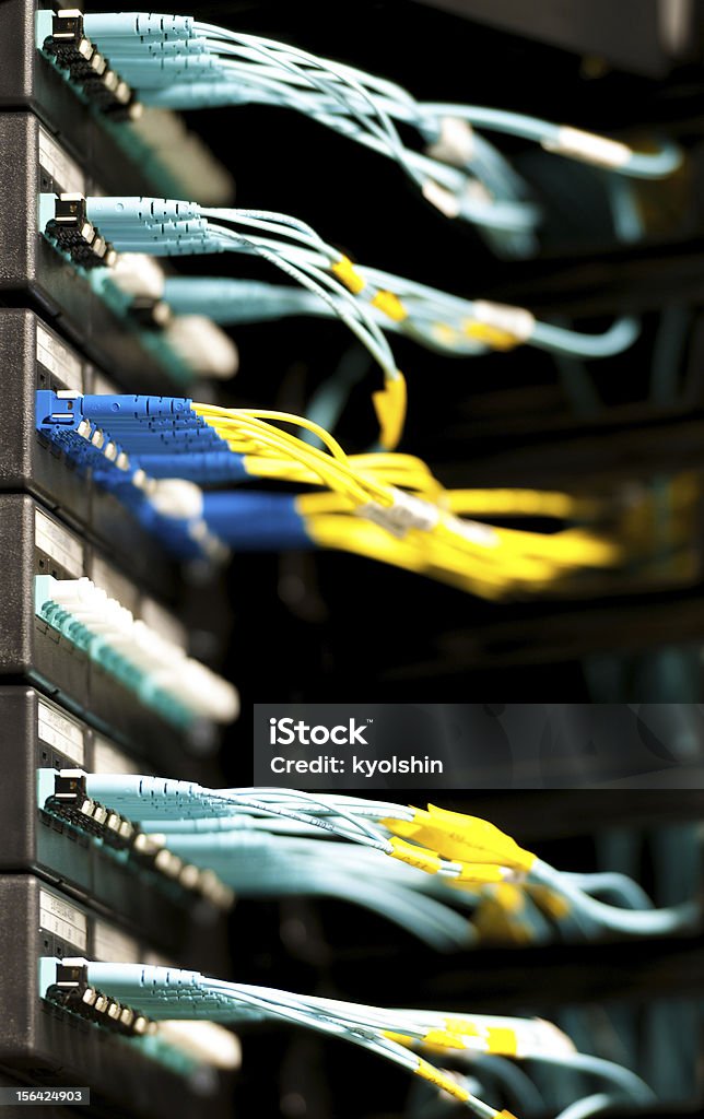Conectado a um painel de cabos de fibra óptica na sala do servidor. - Foto de stock de Fibra óptica royalty-free