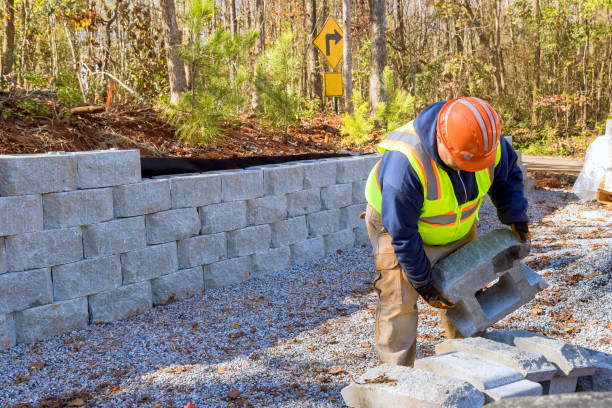 Construction worker is currently working on building retaining wall while constructing wall a retaining in new property. stock photo
