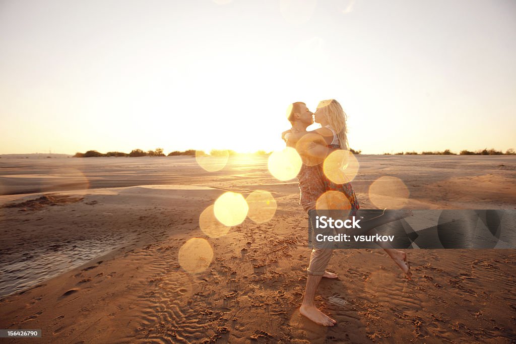 couple on the beach in evening happy couple on the beach in evening Kissing Stock Photo
