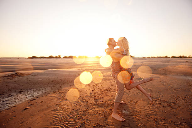 couple on the beach in evening stock photo