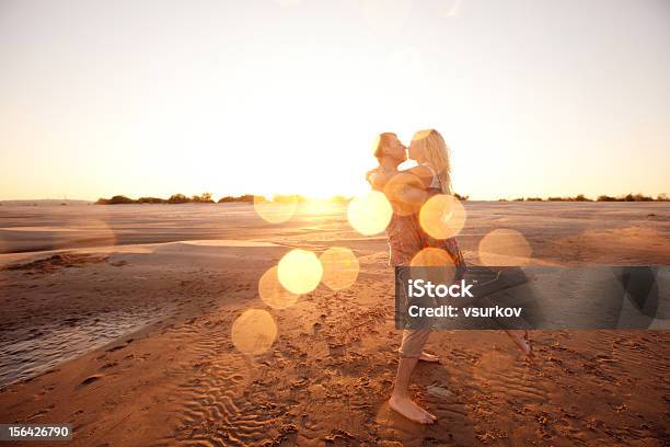 Couple On The Beach In Evening Stock Photo - Download Image Now - Kissing, Couple - Relationship, Beach