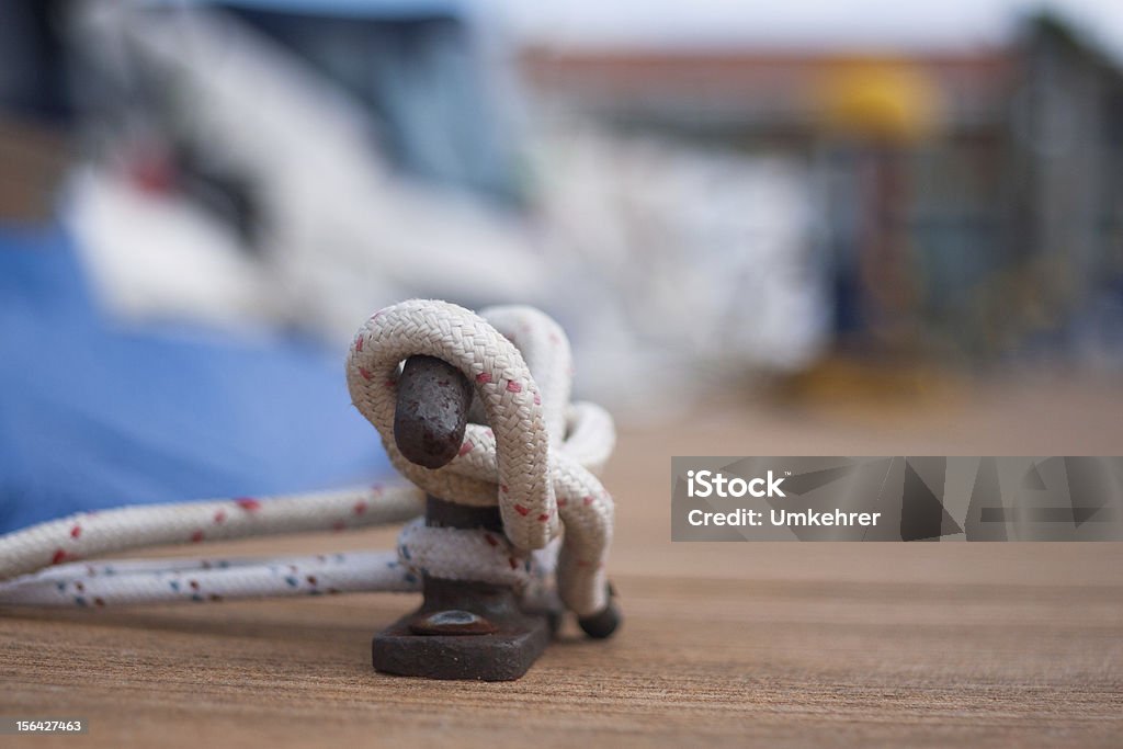 Ship rope on harbour A ship robe on a harbour in front of ships. short focus. ships in background Blue Stock Photo