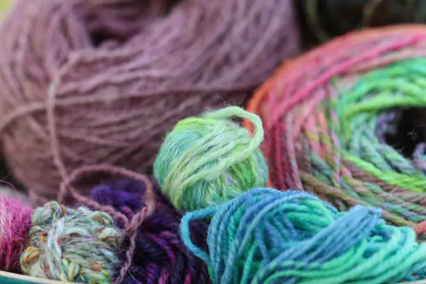 Beautiful balls of handspun yarn wool of a colourful skein of organic natural handspun and handdyed merino sheep wool, silk, linnen mix yarn fleece, spun on a traditional spinning wheel.