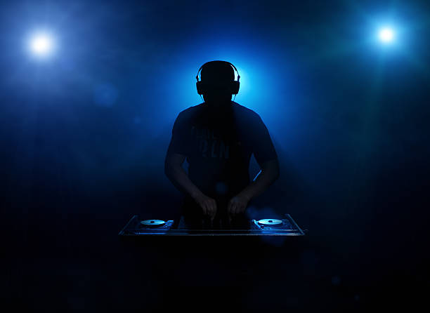 DJ silhouette Silhouette of a disc jockey mixing in the night club with copy space dj photos stock pictures, royalty-free photos & images