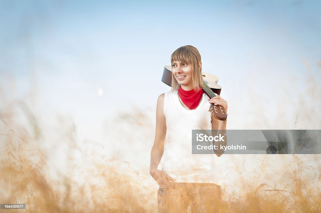 Mujer con guitarra standing en el prado de otoño. - Foto de stock de Adulto libre de derechos