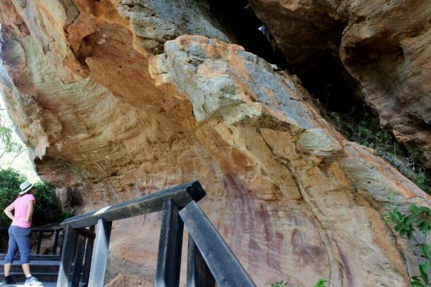 mulher australiana olhar para a pintura de arte rupestre indígena australiana península de cape york queensland austrália - aboriginal rock art - fotografias e filmes do acervo