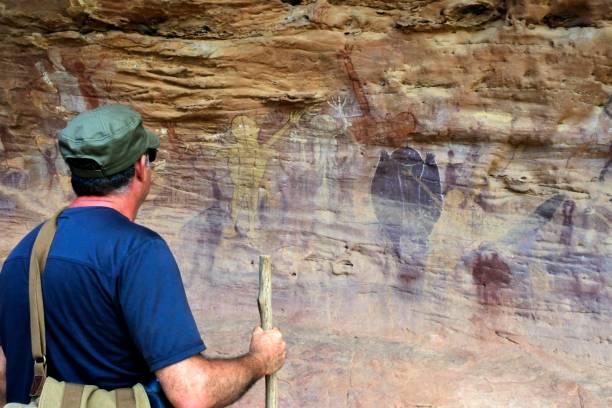 homem australiano olha para a pintura de arte rupestre indígena australiana península de cape york queensland austrália - aboriginal rock art - fotografias e filmes do acervo