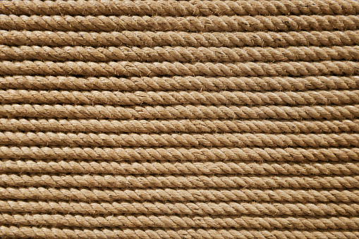 Beige brown grungy round twisted strong rope from nautical industry material craft pattern textured background