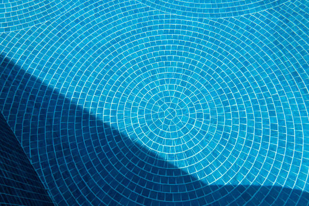 Curved stairs into blue swimming pool with clean fresh blue water, view from above