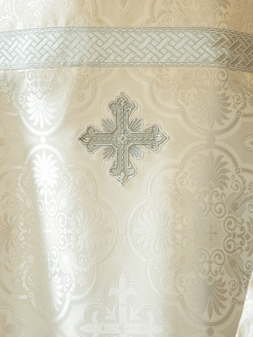 Cloth of a cassock close up. Liturgical clothes, liturgical vestments, robes. Embroidery symbol on the priest's cassock religion clothing orthodox.