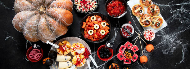 istock Halloween sweets for Halloween party on black background. top view 1564381889