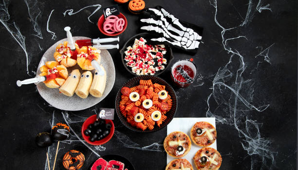 istock Halloween sweets for Halloween party on black background. top view 1564388736