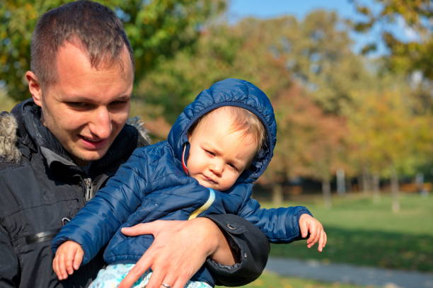 istock Father holding his son in park 1564390363
