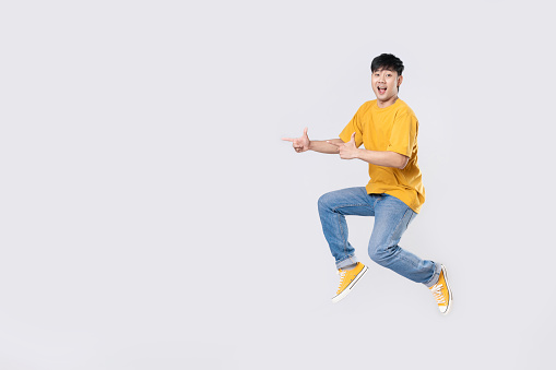 Surprised young man jumping, isolated on white