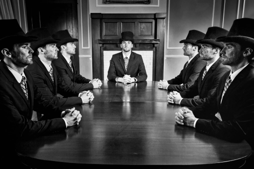 Black & White image of a businessman clones on a meeting.