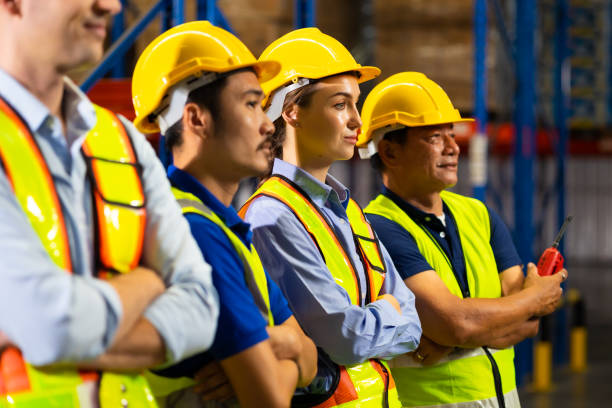 istock stand with arms crossed. Unity and teamwork concept. team standing hands together. Professional Mechanical Engineer team Working at warehouse store. 1564455706