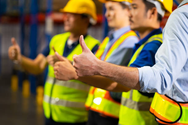 istock Thumb up. Unity and teamwork concept. team standing hands together. Professional Mechanical Engineer team Working at warehouse store. 1564455715
