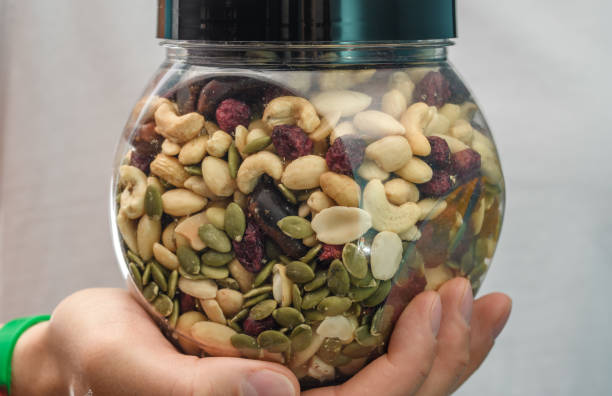 istock A mixture of various nuts and dried fruits held in the hands in a plastic container 1564460619
