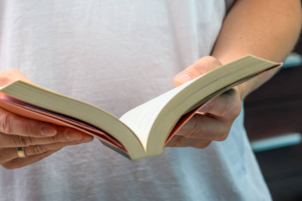 istock An open book held in hands, a man reading a book 1564462260
