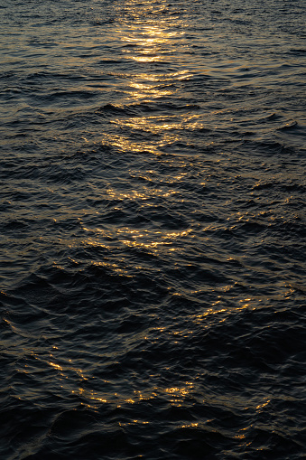 the water surface of a river or lake with sun glare at sunset