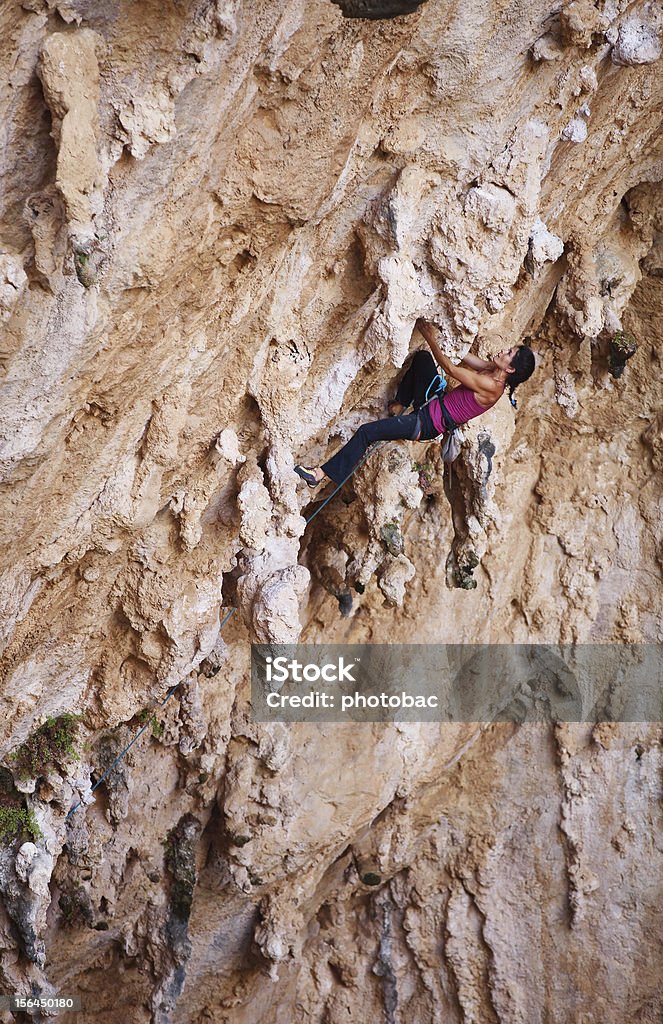 Femminile rock alpinista su una scogliera - Foto stock royalty-free di Adulto