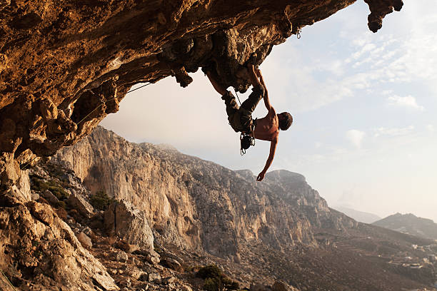 A rock climber hanging on a cliff on a sunny day