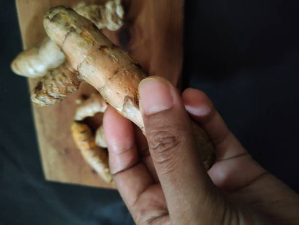 istock fresh turmeric with some green leaves 1564568543
