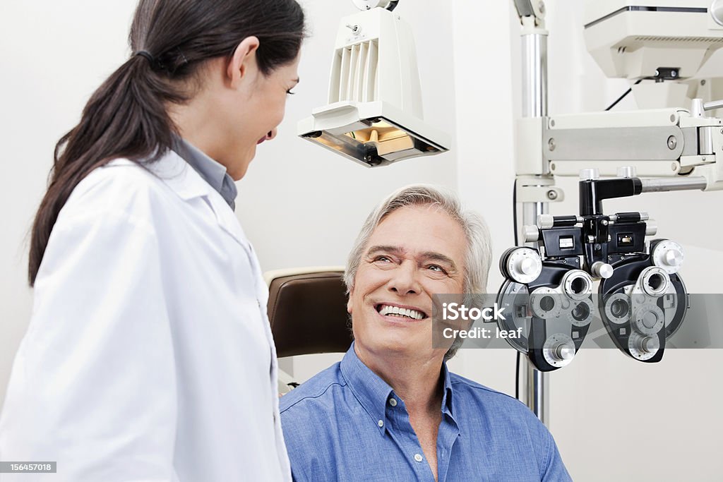 Eye Checkup Smiling mature patient consulting with optometrist for an eye checkup Patient Stock Photo