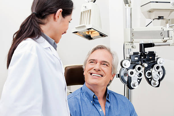 Eye Checkup Smiling mature patient consulting with optometrist for an eye checkup eye care stock pictures, royalty-free photos & images