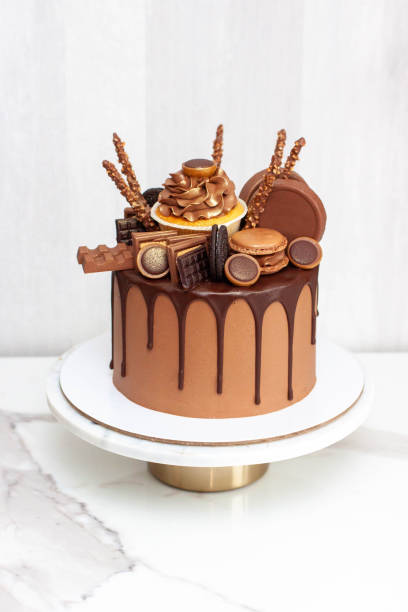 istock Chocolate cake richly decorated with assorted sweets, cupcake, cookies, chocolate bars and macarons 1564583540