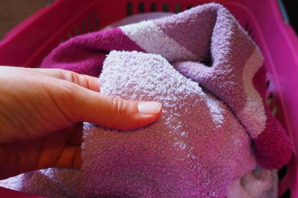 istock A woman's hand is feeling a cotton colored towel from a basket with dirty laundry. Laundry sorting and washing. Laundry room or bathroom. Housekeeping. Pink and blue terry towels. 1564597379