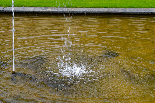 Pond at public park with water fountain at Swiss City of Winterthur on a cloudy spring day. Photo taken May 17th, 2023, Winterthur, Switzerland.