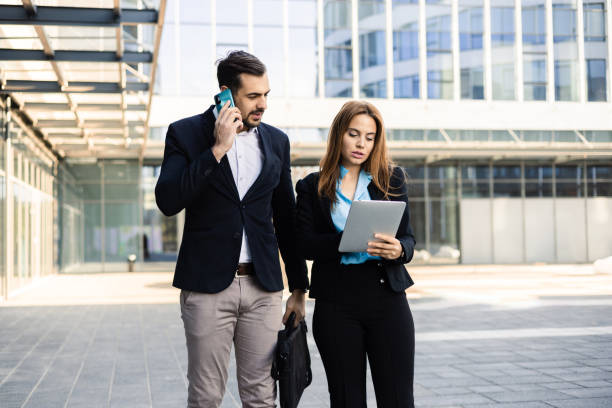 istock Businessman telephoning and his female colleague using tablet 1564603392