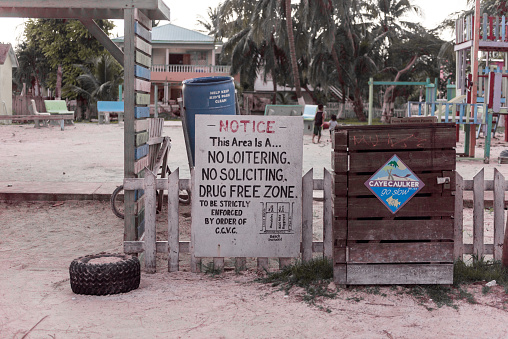 Caye Caulker, Belize - November 19, 2017: Caye Caulker Island in Caribbean Sea. Sandy Street with Drugs Free Zone Sign. Caribbean Island