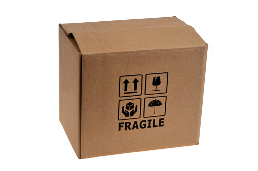 Closed cardboard box with fragile written on it close up on white background