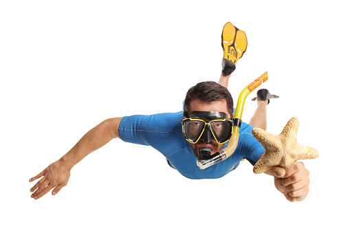 Man in a suit snorkeling with fins and a mask and holding a sea star isolated on white background