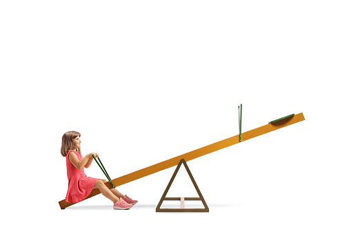 Little girl sitting on a seesaw alone isolated on white background
